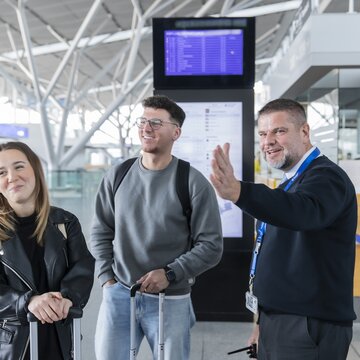 Flughafenmitarbeiter gibt Reisenden am Flughafen Stuttgart Auskunft.