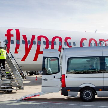 Flugzeug von flypgs.com wird am Flughafen Stuttgart über eine Treppe betreten, daneben steht ein AGS Transporter.