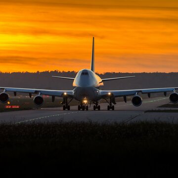 Ein großes Flugzeug auf dem Rollfeld des Flughafen Stuttgart bei Sonnenuntergang.